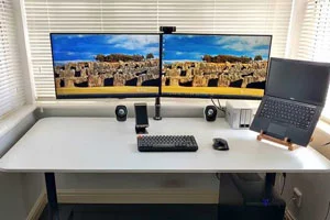 Thumbnail image showing a photograph of a PC, 2 monitors, a keyboard and mouse, all sitting on a large desk in a bay window.