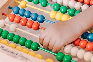 Thumbnail image showing a child counting with an abacus. Photo by luis arias on Unsplash 